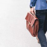Un uomo cammina con una valigetta in pelle