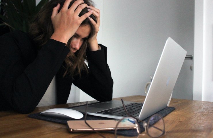 Donna al computer con le mani tra i capelli