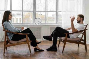 Seduta di psicoterapia tra uomo e psicologa donna
